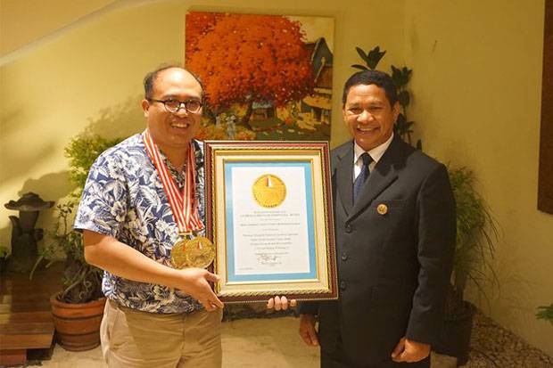 Prof Josaphat Tetuko Sri Sumantyo, Ph.D (kiri) memperlihatkan penghargaan Lembaga Prestasi Indonesia Dunia bersama Direktur Utama Leprid Paulus Pangka.