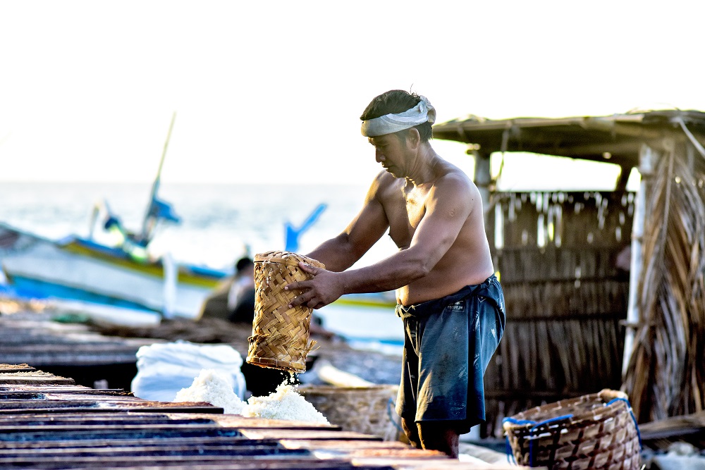 Seorang petani yang sedang memanen garam laut di Tejakula, Buleleng, Bali