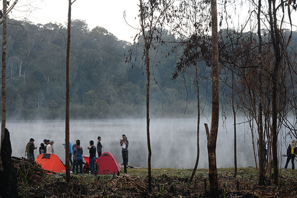 Pengunjung menikmati suguhan panorama telaga di pagi hari yang sangat memikat dengan kabut yang memenuhi permukaan air telaga. (Foto: bmzIMAGES/Basri Marzuki)