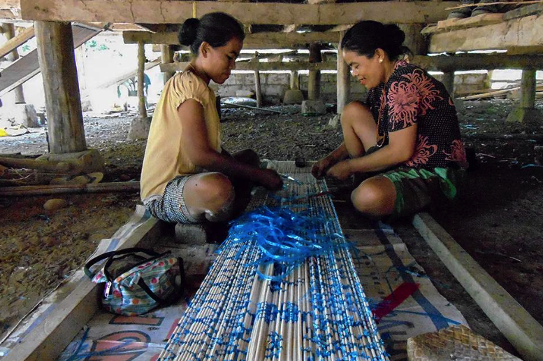 Mengikat kain tenun Sumba