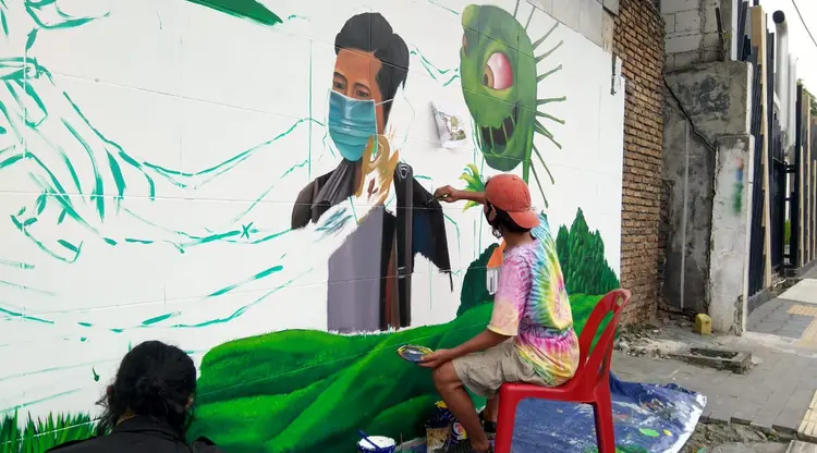 Komunitas Mural Medan tengah melukis mural di sebuah tembok yang berada di Jalan Stasiun Kereta Api (19/09/2020)Sumber:Liputan6.com