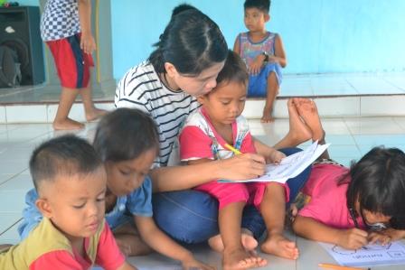 Relawan yang membimbing anak-anak untuk mewarnai | Foto: Mona Destiana