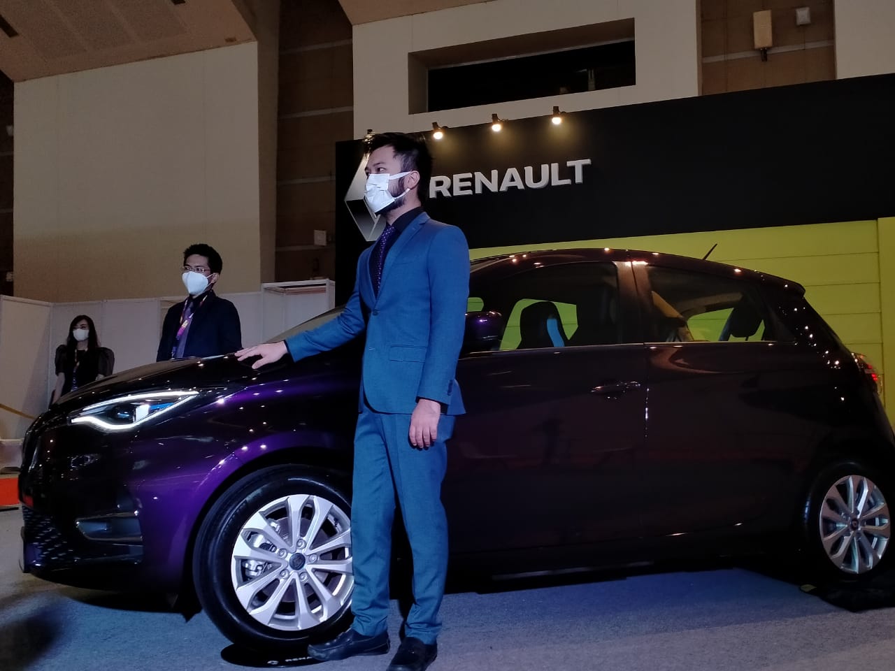 Beberapa orang di salah satu stand otomotif menggunakan masker sebagai bentuk peangaplikasian protokol kesehatan. © IIMS