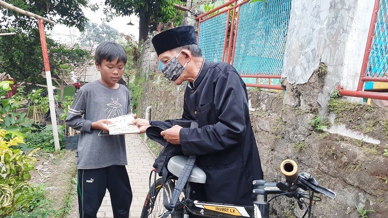 Abah Udju saat memberi pinjaman buku