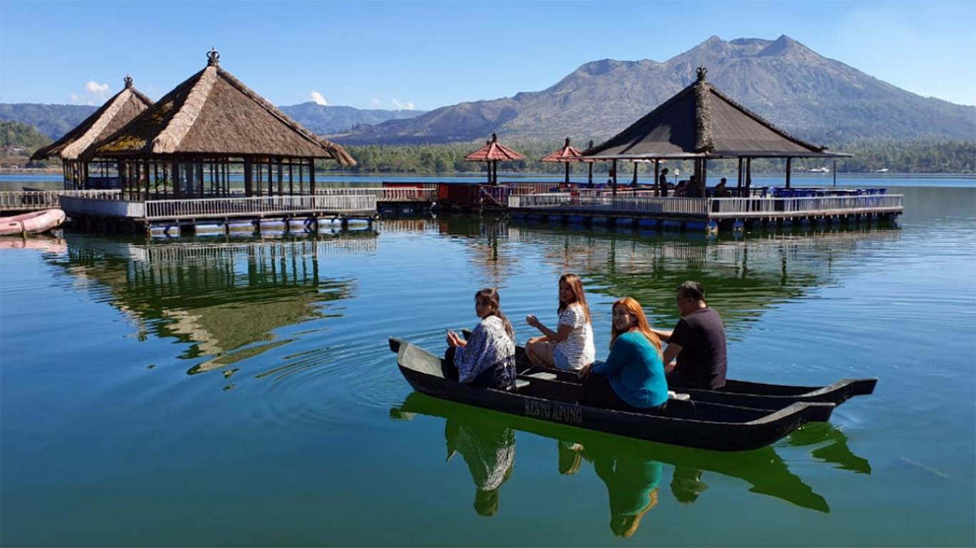 Menaiki perahu saat berwisata ke Danau Batur Bali di kaki Gunung Batur, danau alam indah di Pulau Bali
