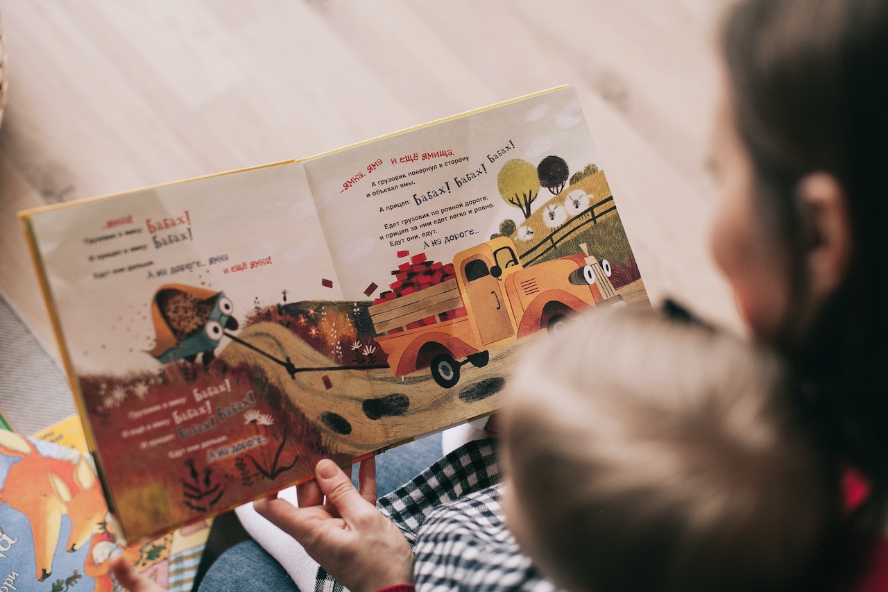 Anak sedang membaca buku bersama ibunya
