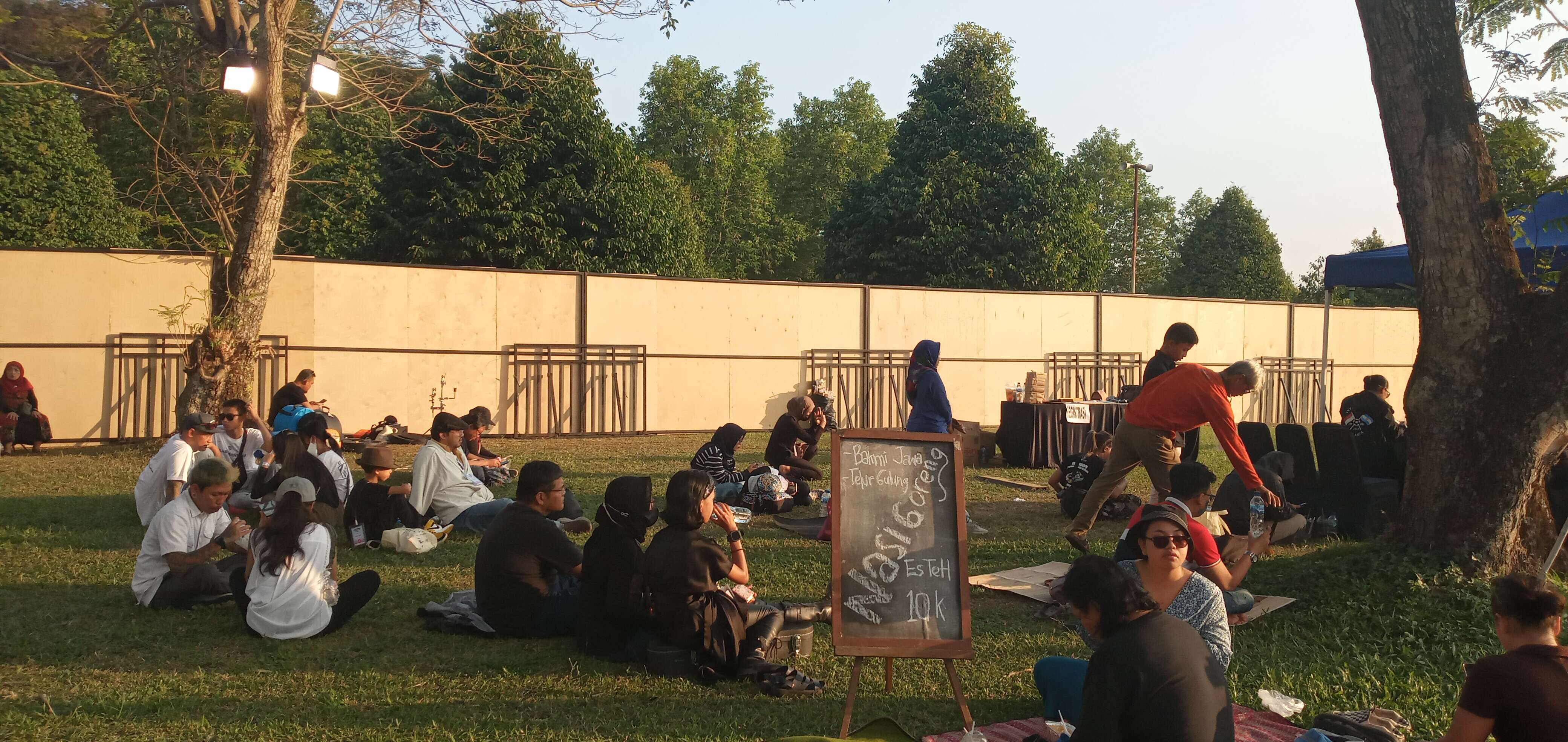 Para pengunjung tampak bercengkerama di hamparan luput dekat stand Pasar Kangen Prambanan Jazz Festival 2023. | Foto: Dokumen Pribadi