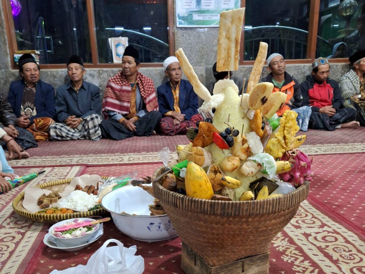 Makanan yang disajikan berupa nasi tumpeng, ayam ingkung, dan jajanan pasar.