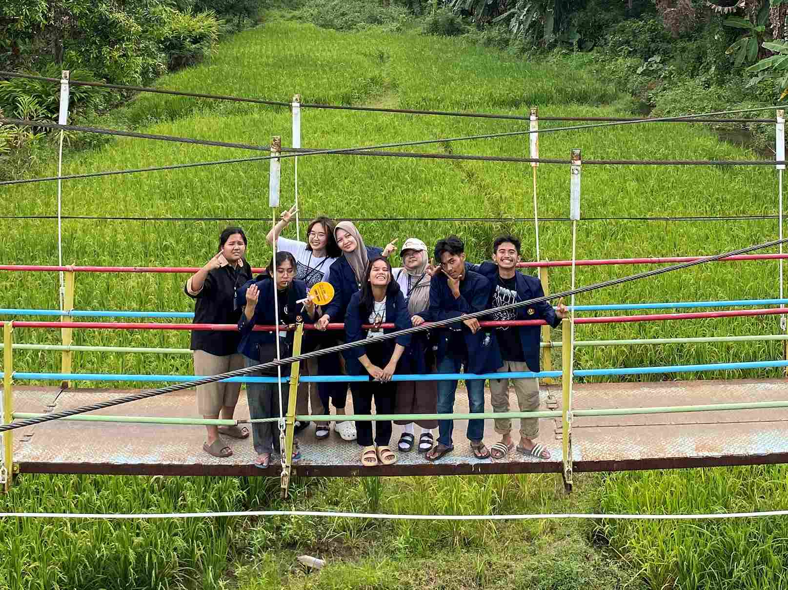 Mahasiswa KKN Unpad di Desa Karedok berswafoto dari atas jembatan gantung Desa Karedok