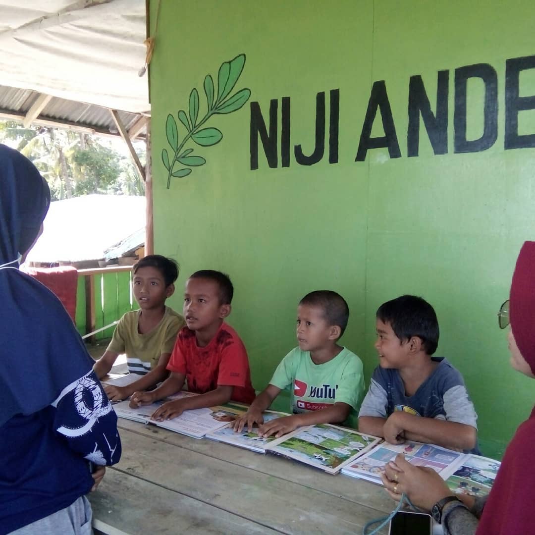 Para relawan pendidikan di komunitas ANDESPIN sedang berbagi ilmu dengan anak-anak setempat di Rumah Baca ANDESPIN