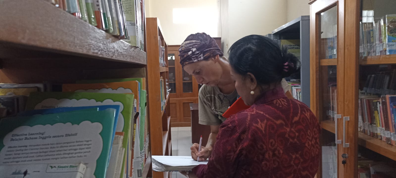 Foto turis sedang mengisi daftar hadir Perpustakaan Kota Denpasar